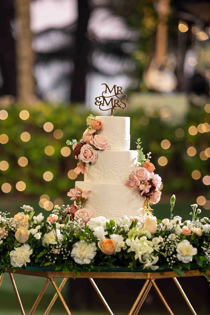 A three-tier wedding cake among dusk florals